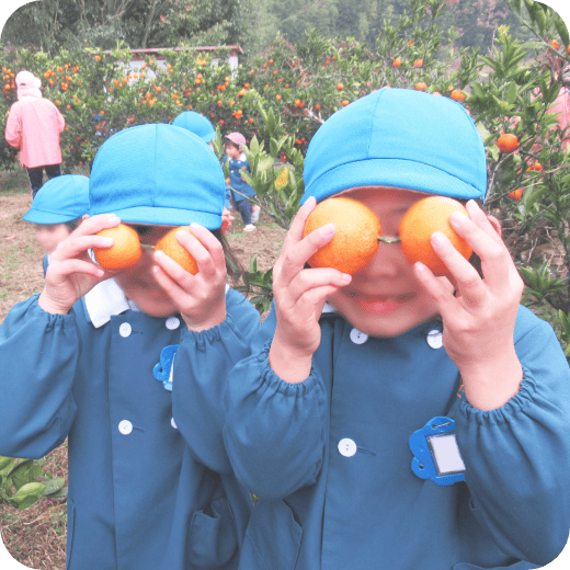 みかんで目を作っっている子どもの写真